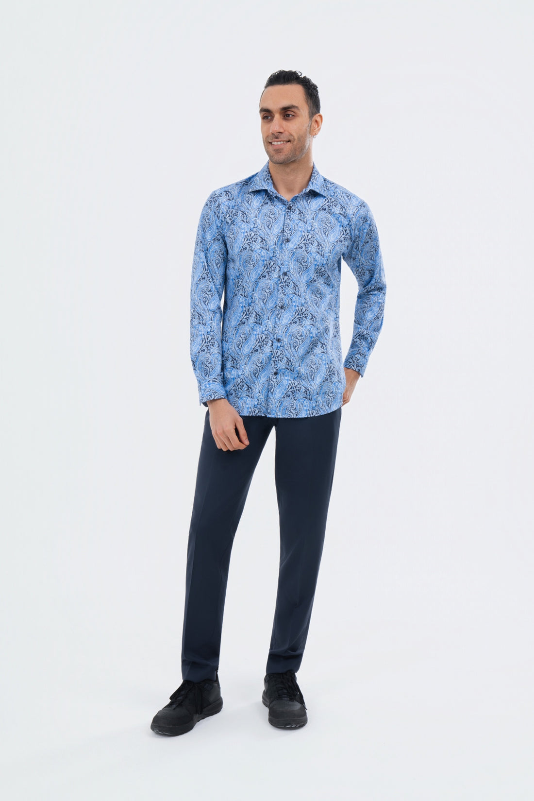 Male model wearing a blue paisley shirt with navy trousers.