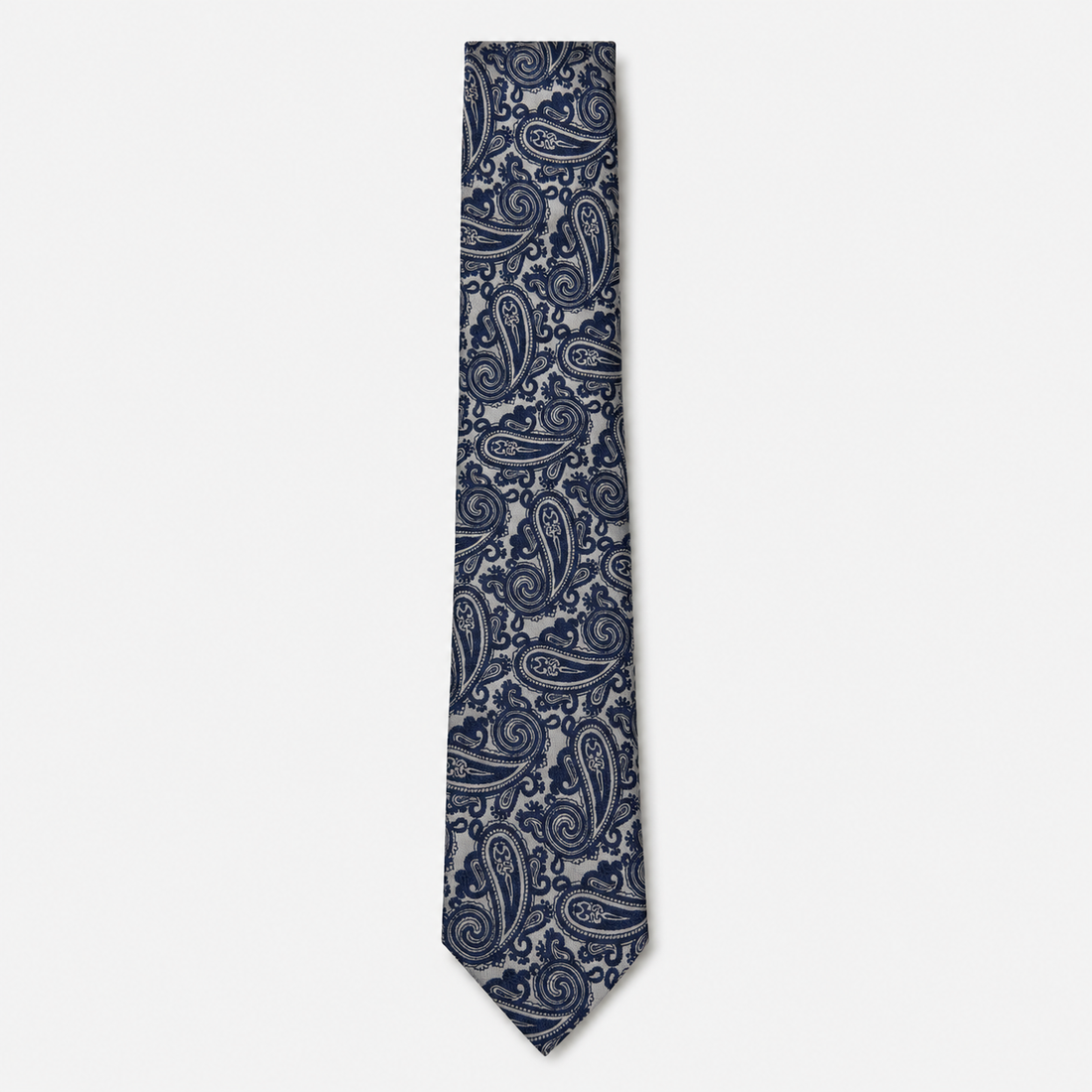 The Grosseto Tie – navy and silver paisley silk tie on a light grey background