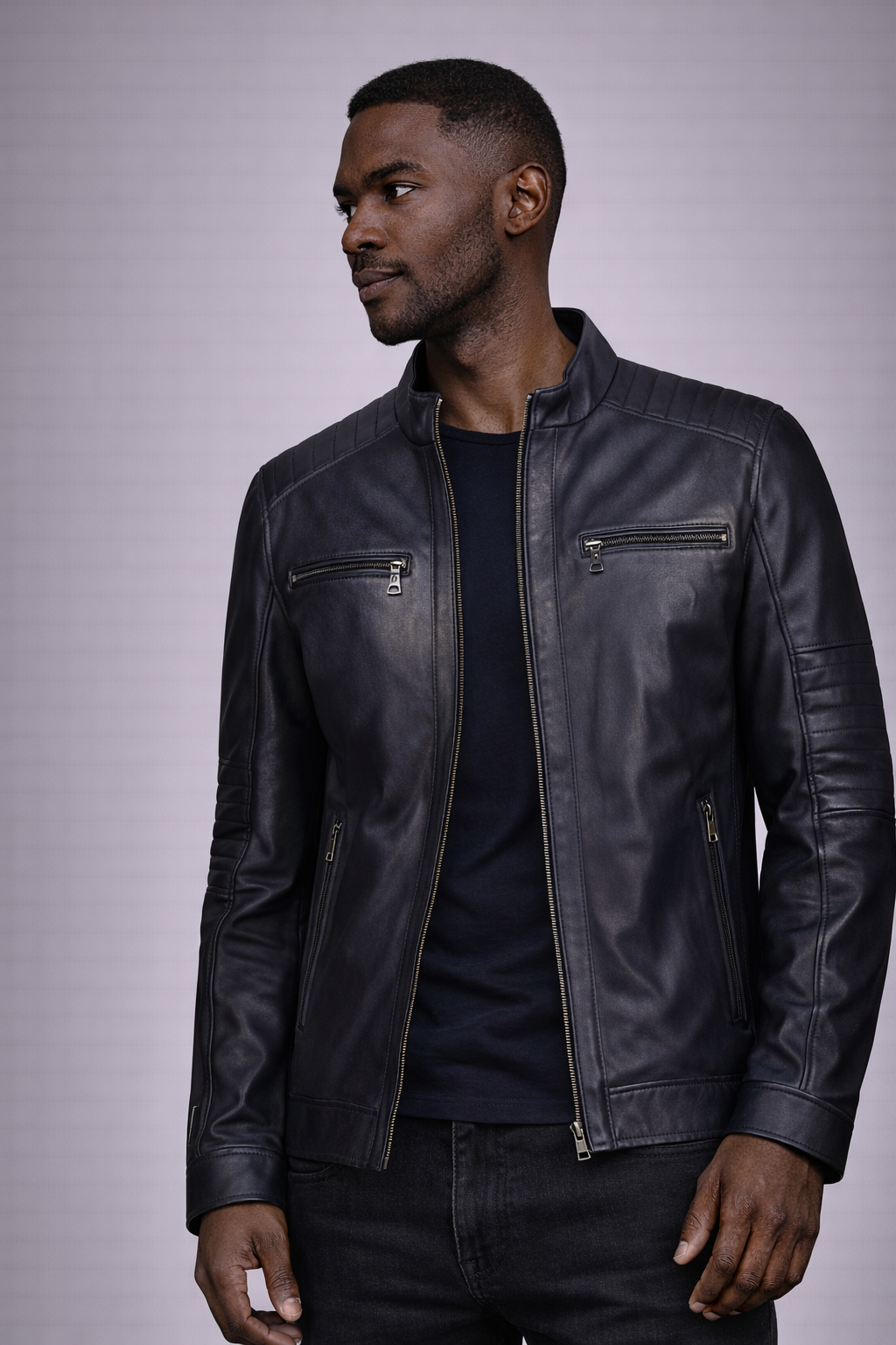 Man wearing a black leather jacket against a gray background
