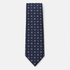 The Orvieto Tie, a navy silk tie with small white geometric dot motifs on a light grey background.