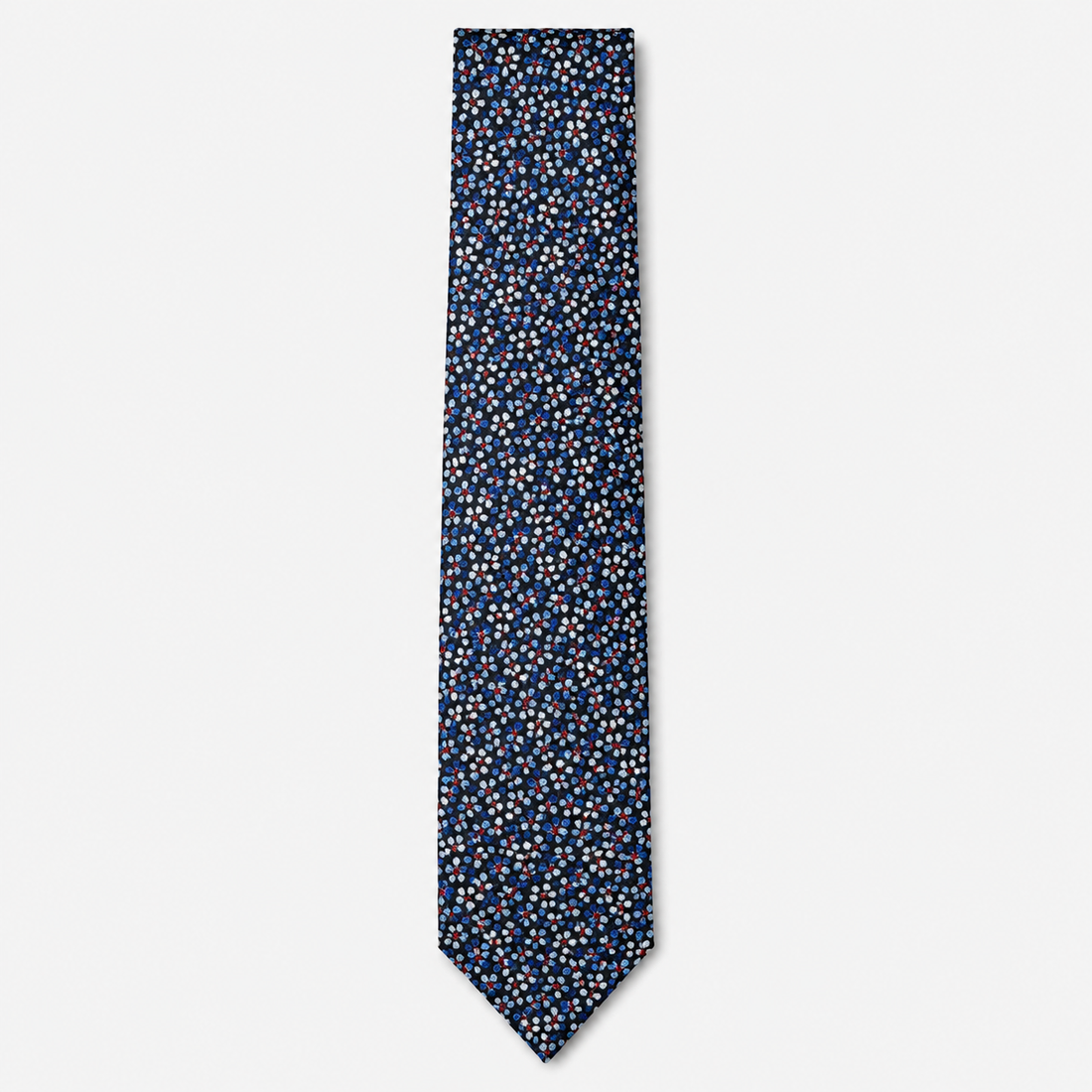 The Vicenza Tie, a navy silk tie with tiny light blue, white and red floral motifs on a light grey background.