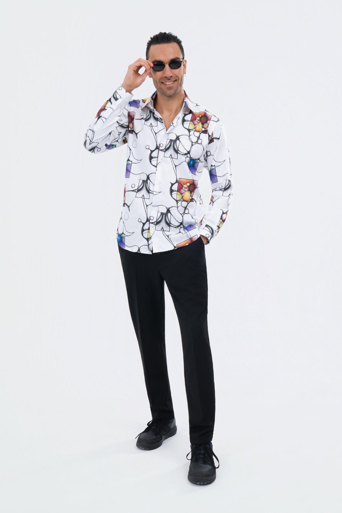 Male model wearing a white illustrated-print shirt with black trousers.